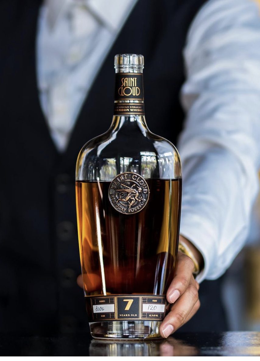 A bartender presenting a bottle of Saint Cloud